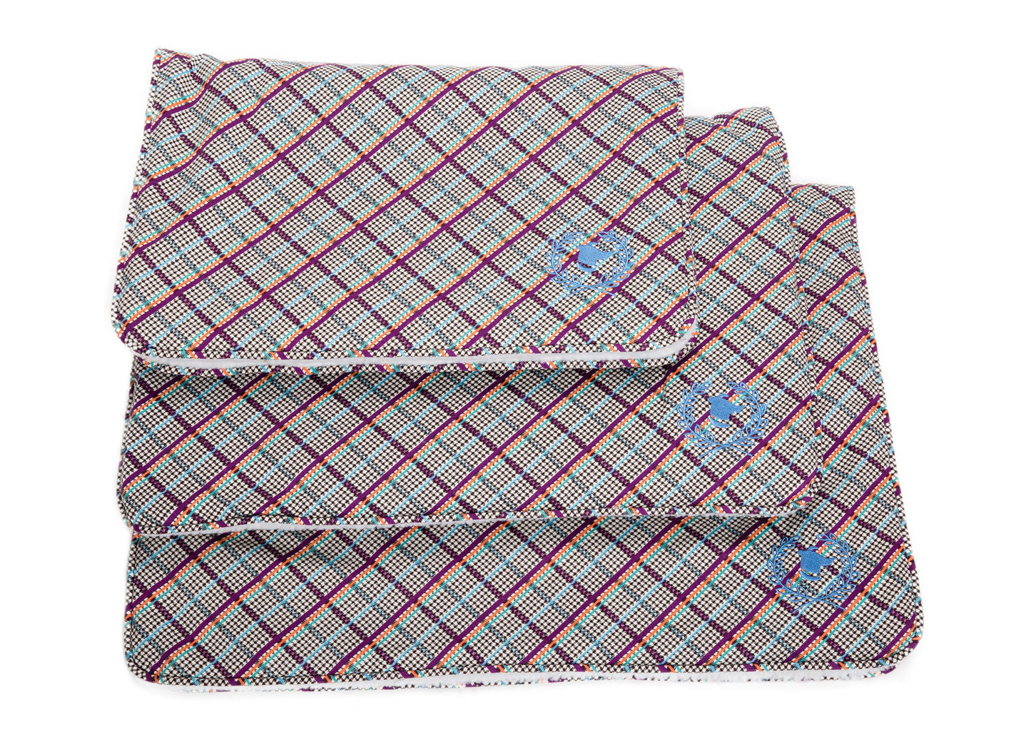A rectangular crate mat with a Milano plaid design featuring colors red, blue, and purple, and a visible brand tag.