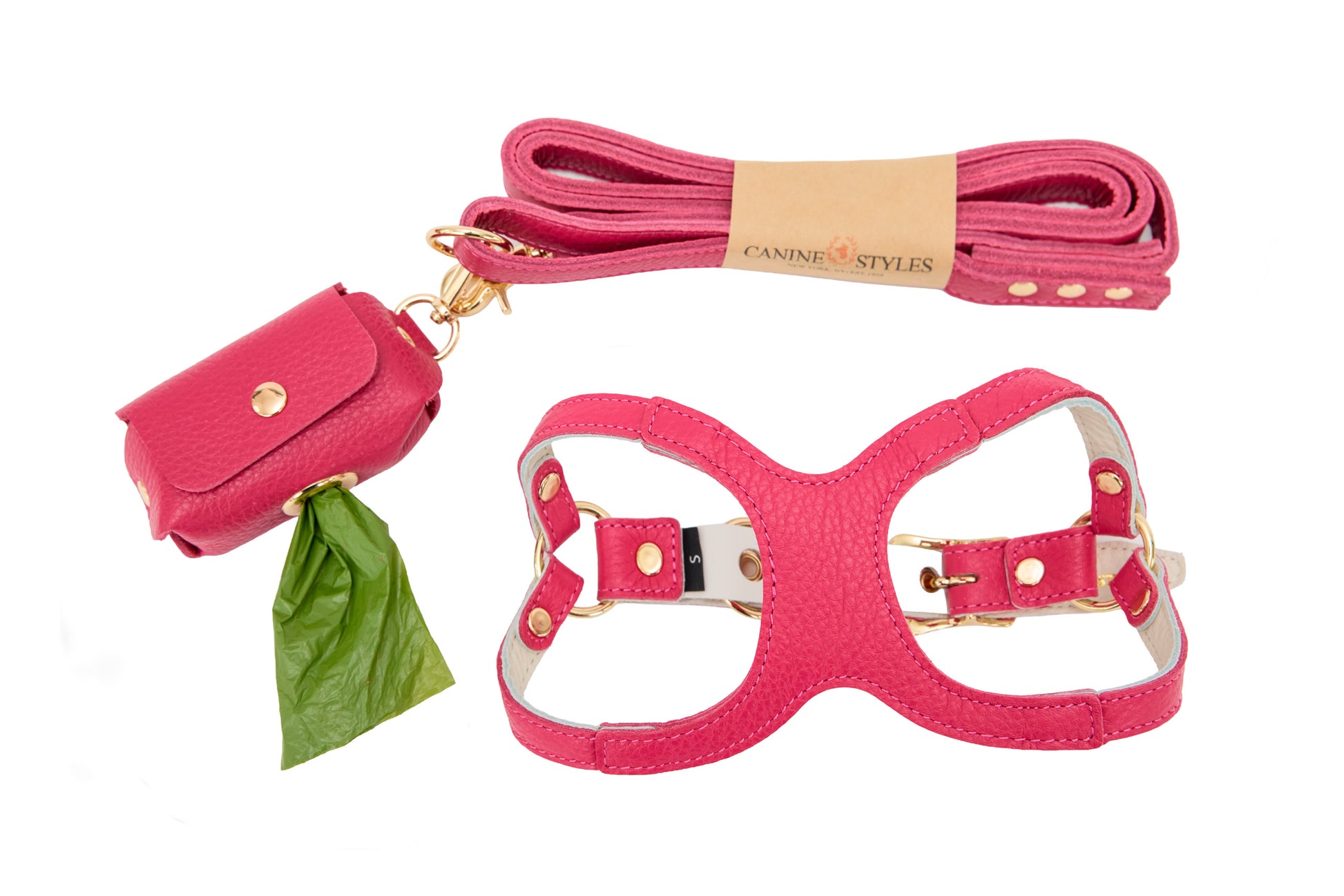 Hot pink dog harness, leash, and poop bag holder set on a white background