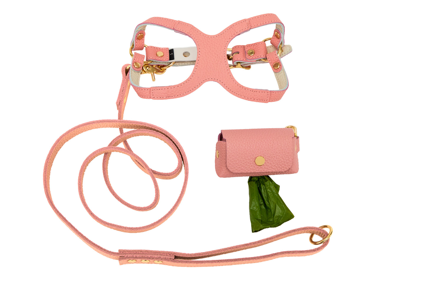 Light pink dog harness, leash, and waste bag holder set on a white background