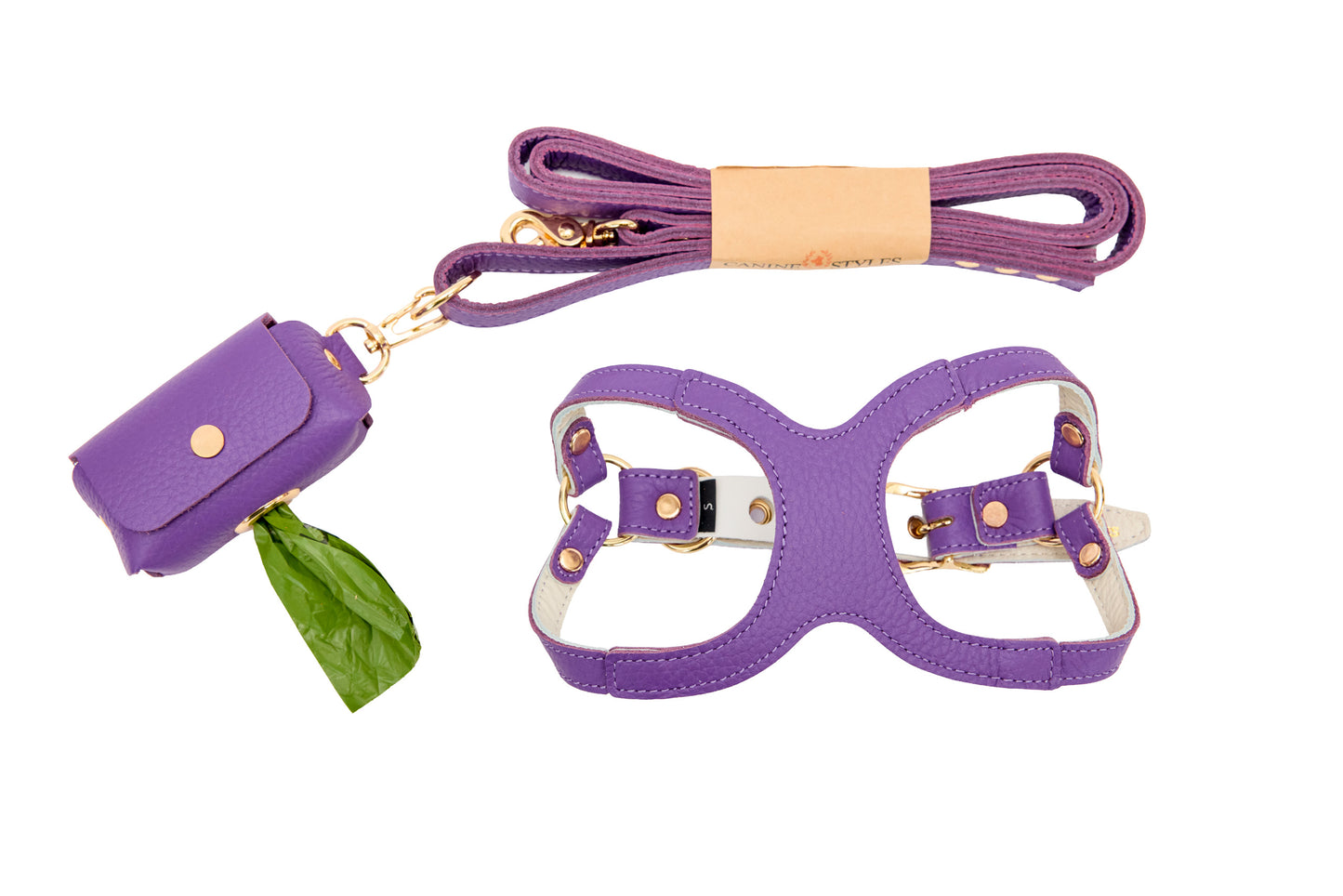 Purple leather harness, matching leash and poop bag holder on a white background