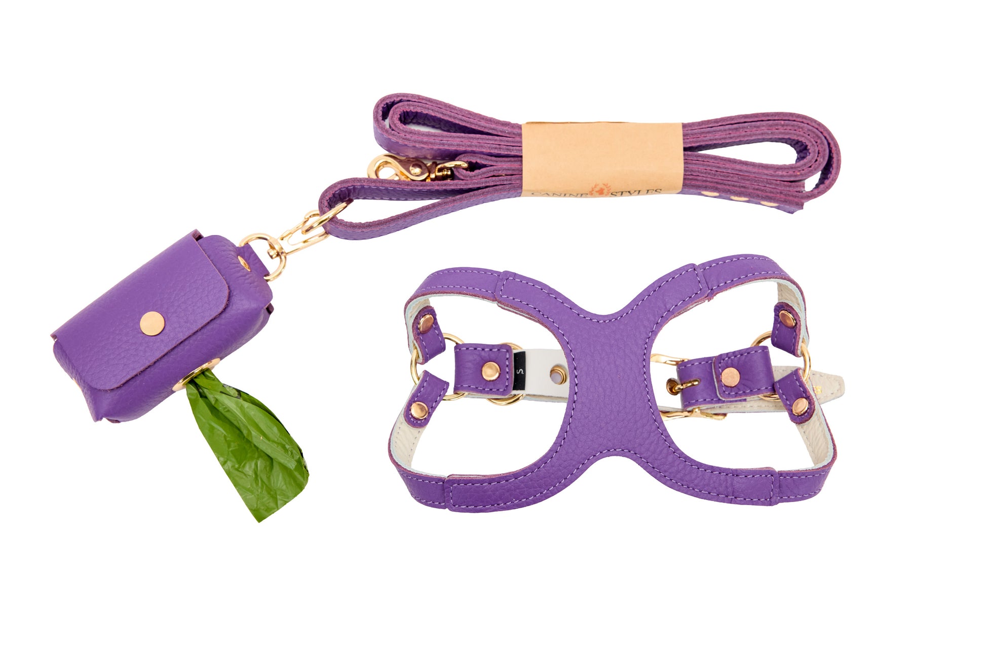 Purple leather harness, matching leash and poop bag holder on a white background