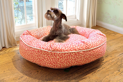Dog sitting on a pink patterned dog bed