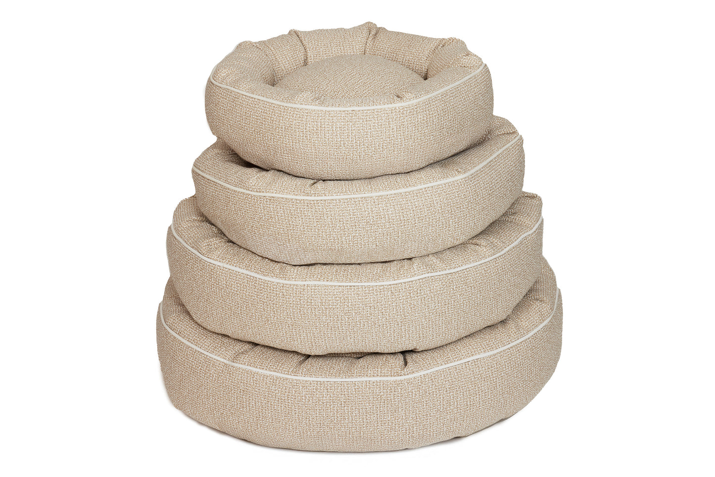 A stack of beige cotton canvas dog beds in various sizes with a round shape and raised edges.