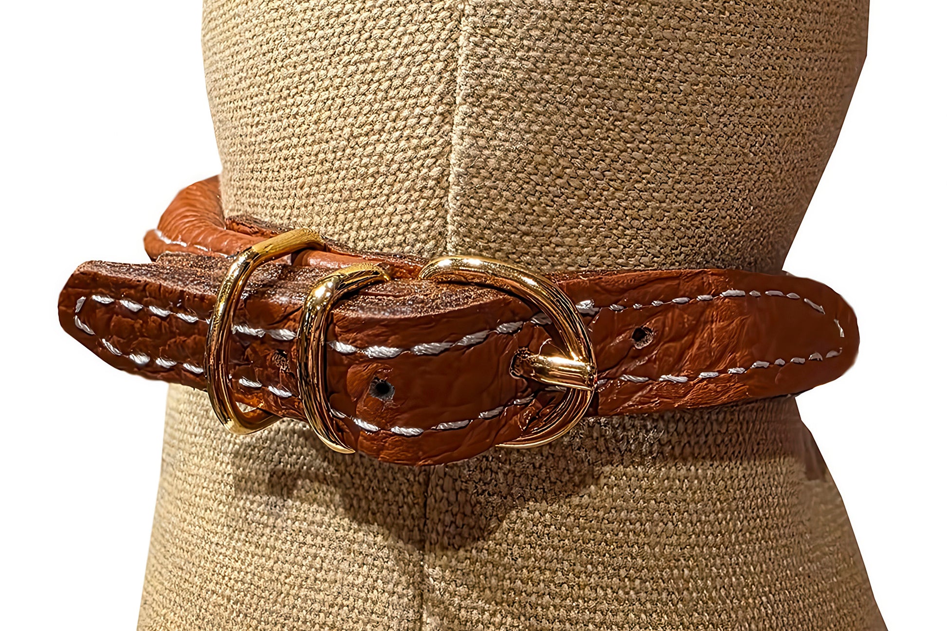 Brown leather belt with gold buckle on a mannequin wearing a beige hat.